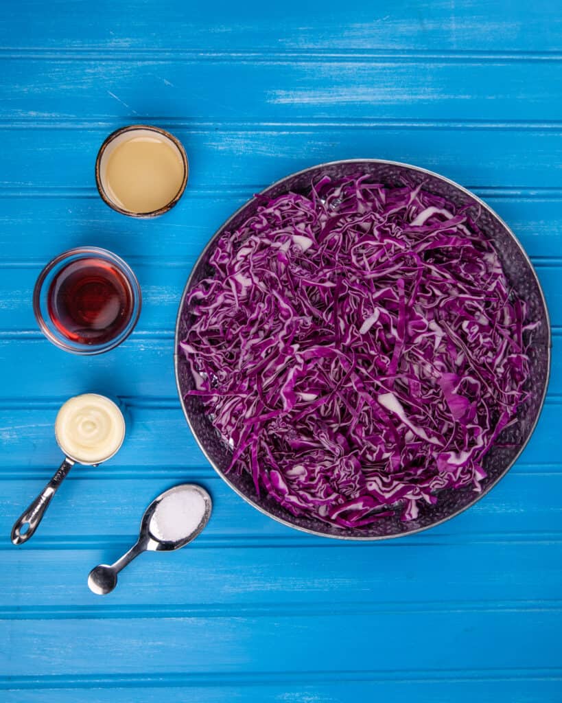 Shredded red cabbage with ingredients for a coleslaw
