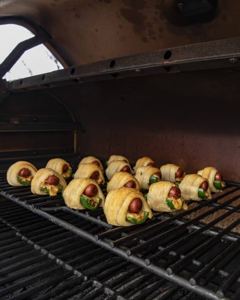 Smoked jalapeño poppers pigs in a blanket on the smoker